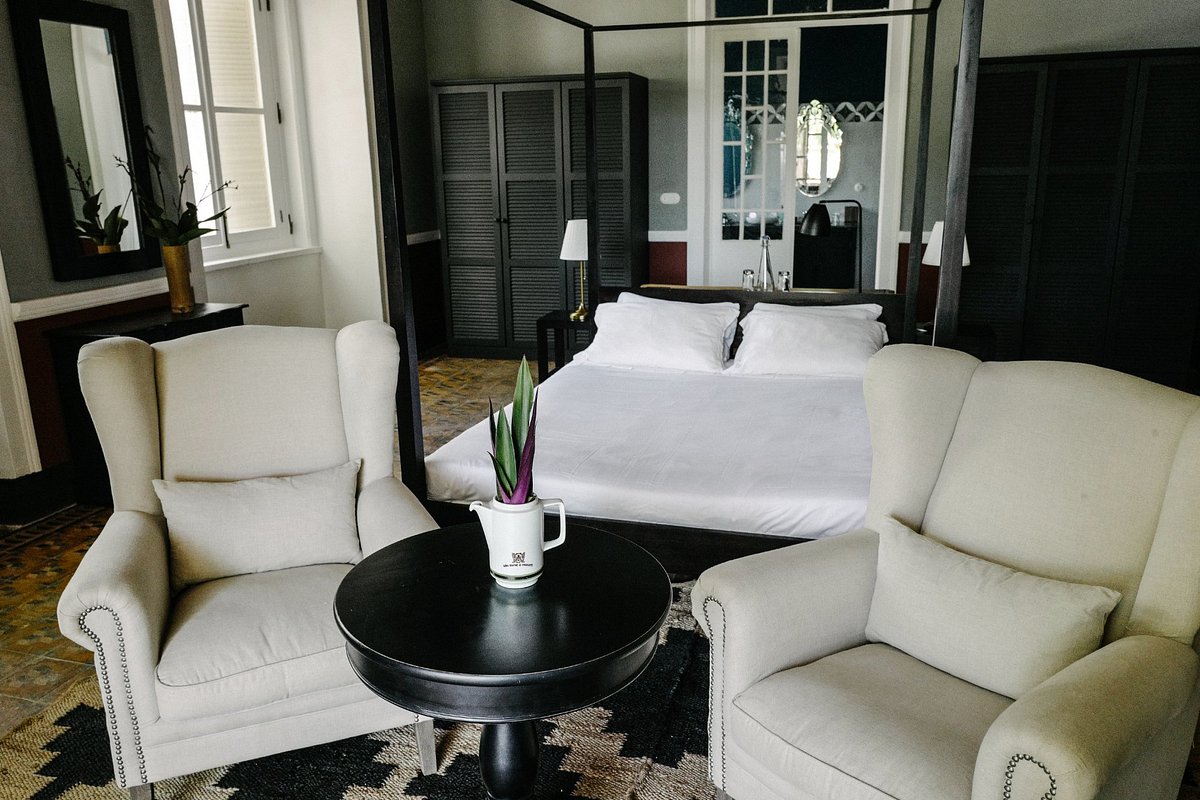 Roça Sundy heritage suite with four-poster bed and wing armchairs