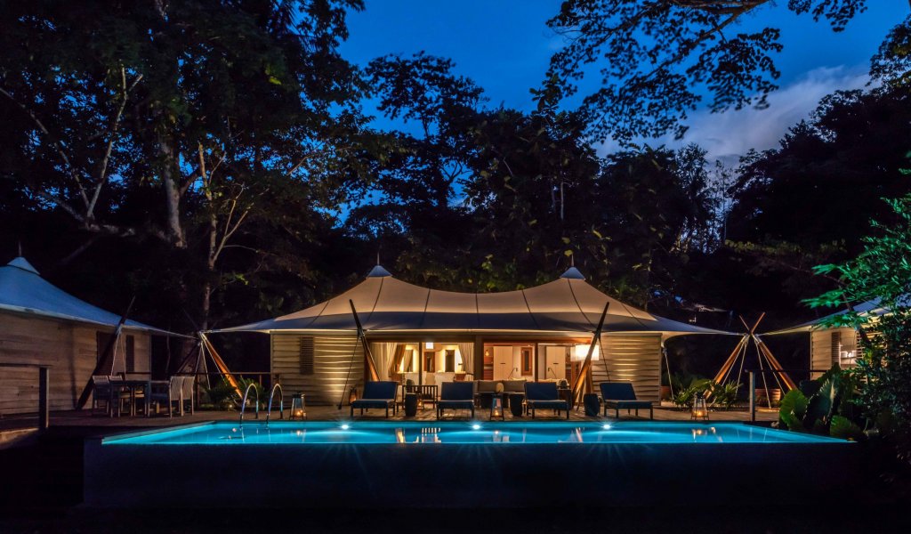 Sundy Praia Principe villa and pool lit at night