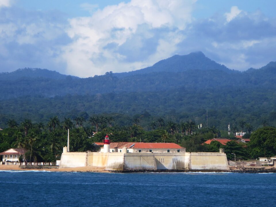 Fort of São Sebastião with São Tomé's forested mountains rising behind it.