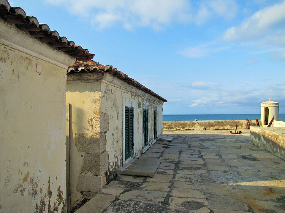 Rampart walkway and weathered buildings inside São Sebastião Fort