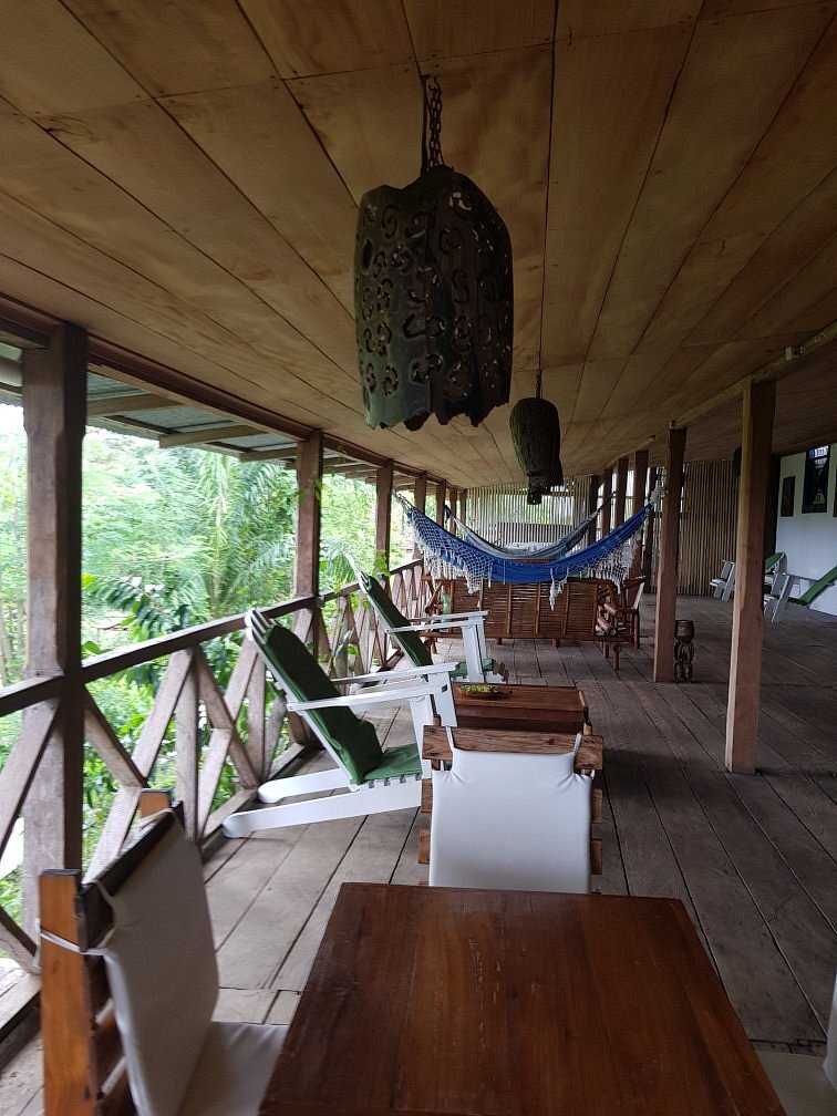 Wooden veranda with a hammock and forest views at Roça São João dos Angolares, São Tomé