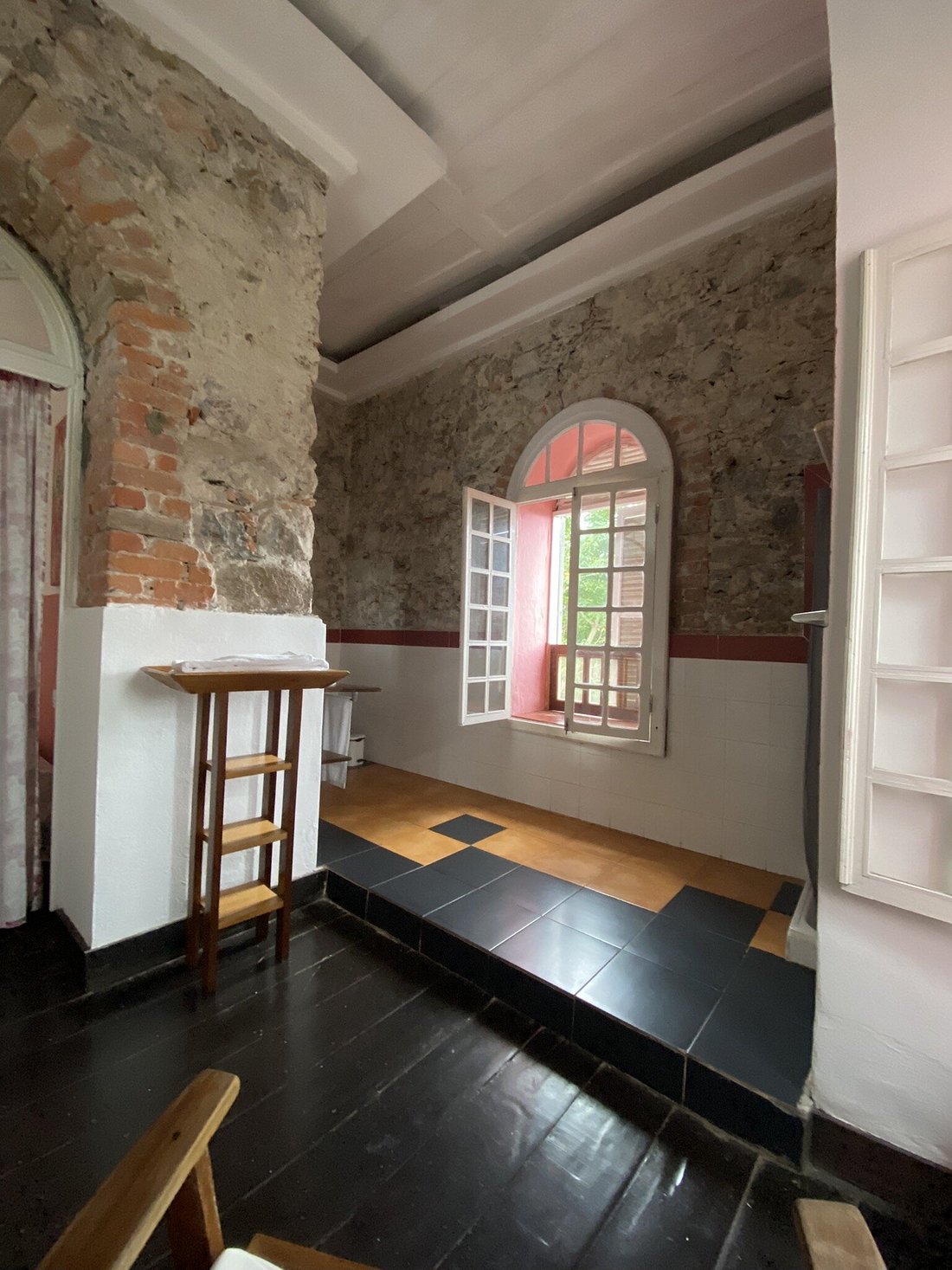 Guest room with exposed stone walls in the historic plantation house, Roça São João dos Angolares