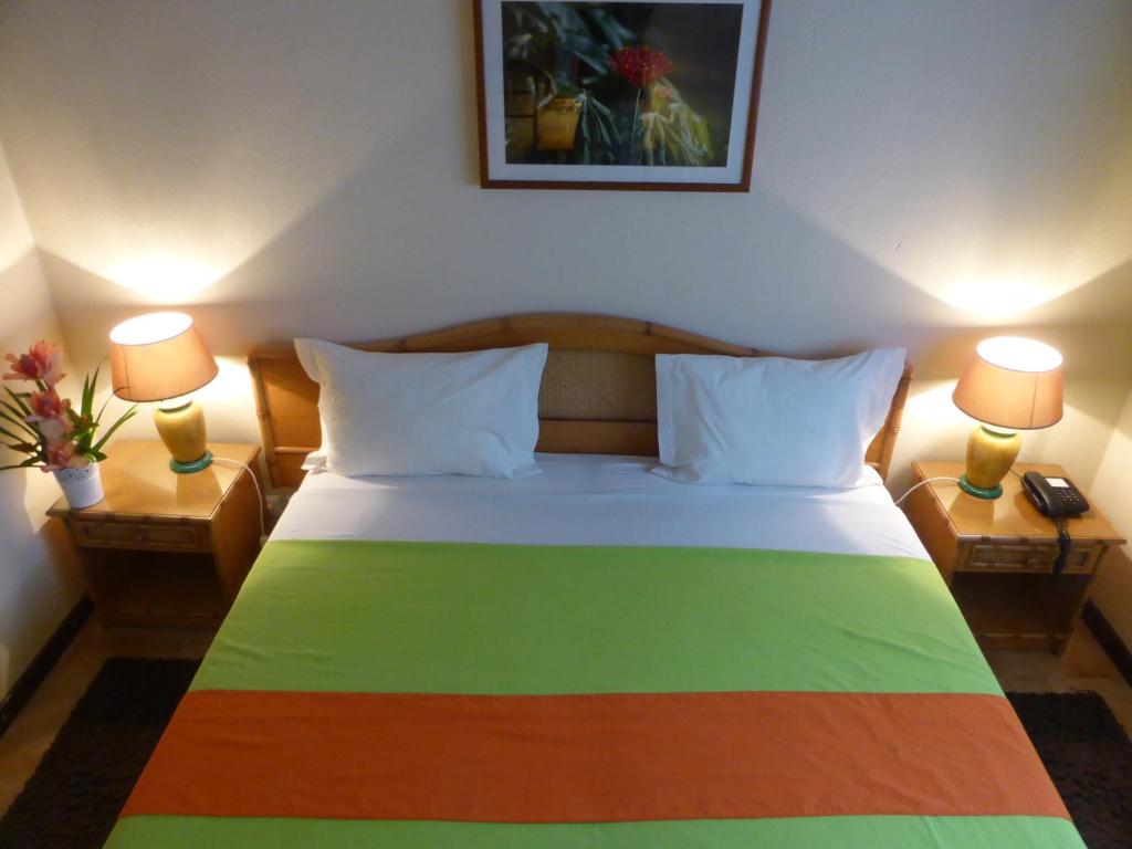 Bungalow bedroom with twin lamps and bamboo furnishings at Club Santana, São Tomé