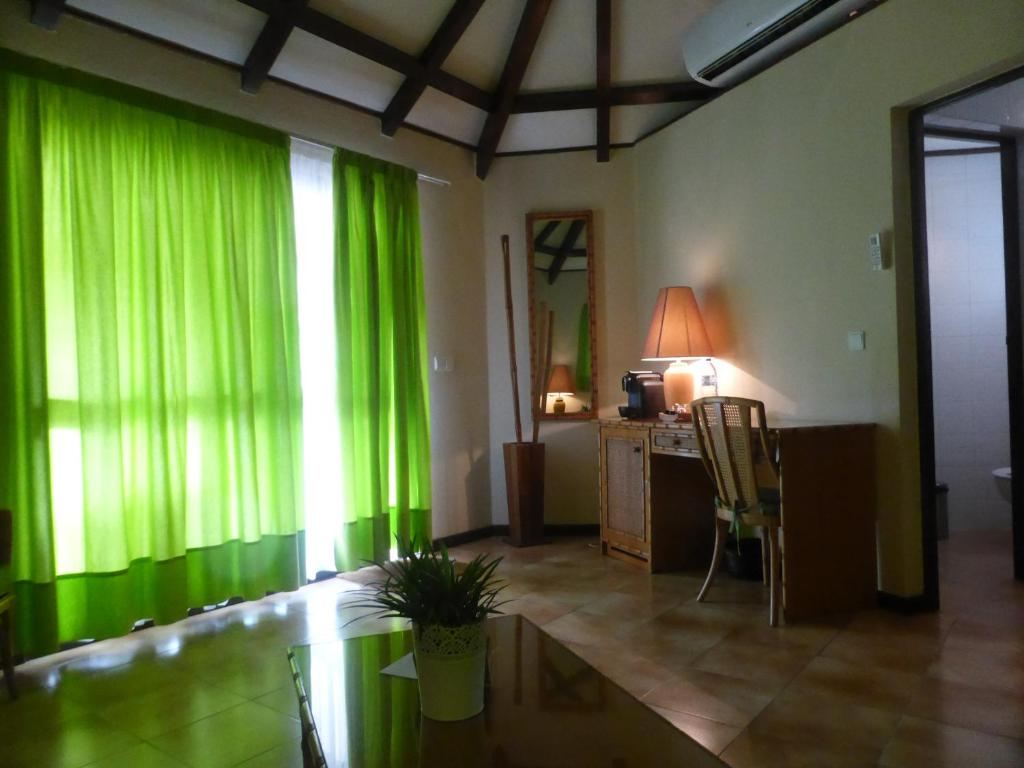 Garden-view bungalow room with a seating area at Club Santana, São Tomé