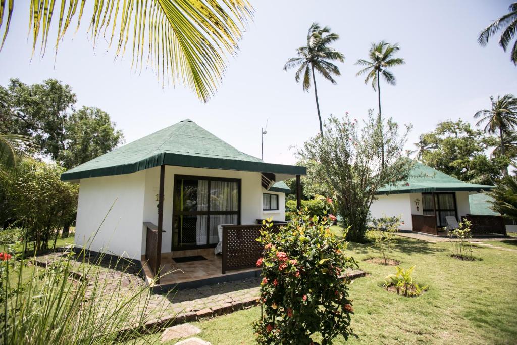Green-roofed sea-view bungalow in tropical gardens at Club Santana, São Tomé