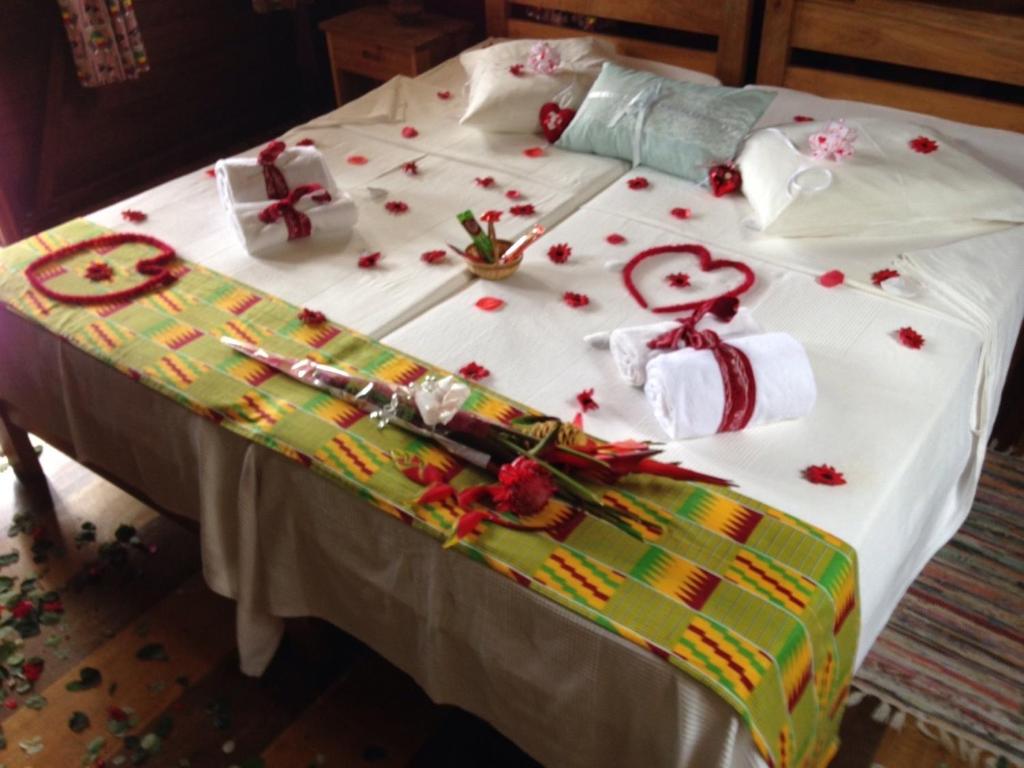 Bed dressed with flowers and local kente cloth at Praia Inhame Eco Lodge