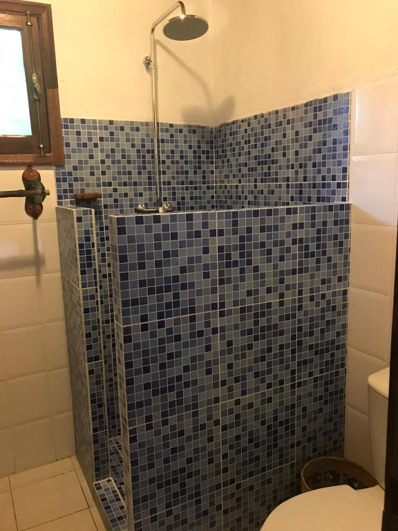 Blue-mosaic tiled shower in a chalet bathroom at Praia Inhame Eco Lodge