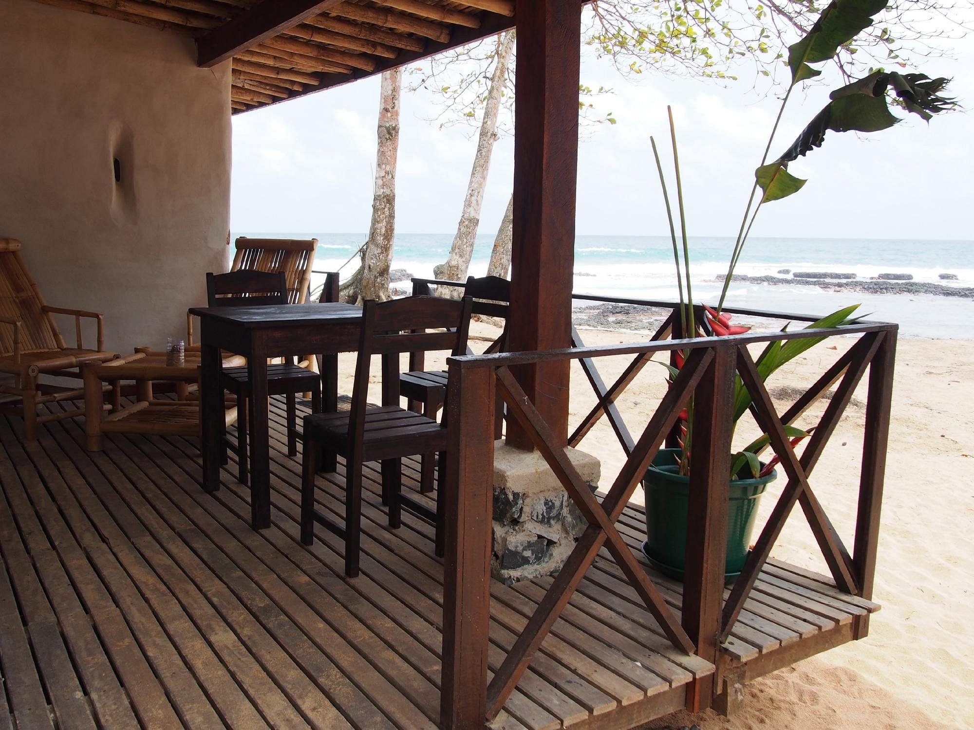 Covered beachfront terrace with dining table overlooking the surf at Jalé Ecolodge