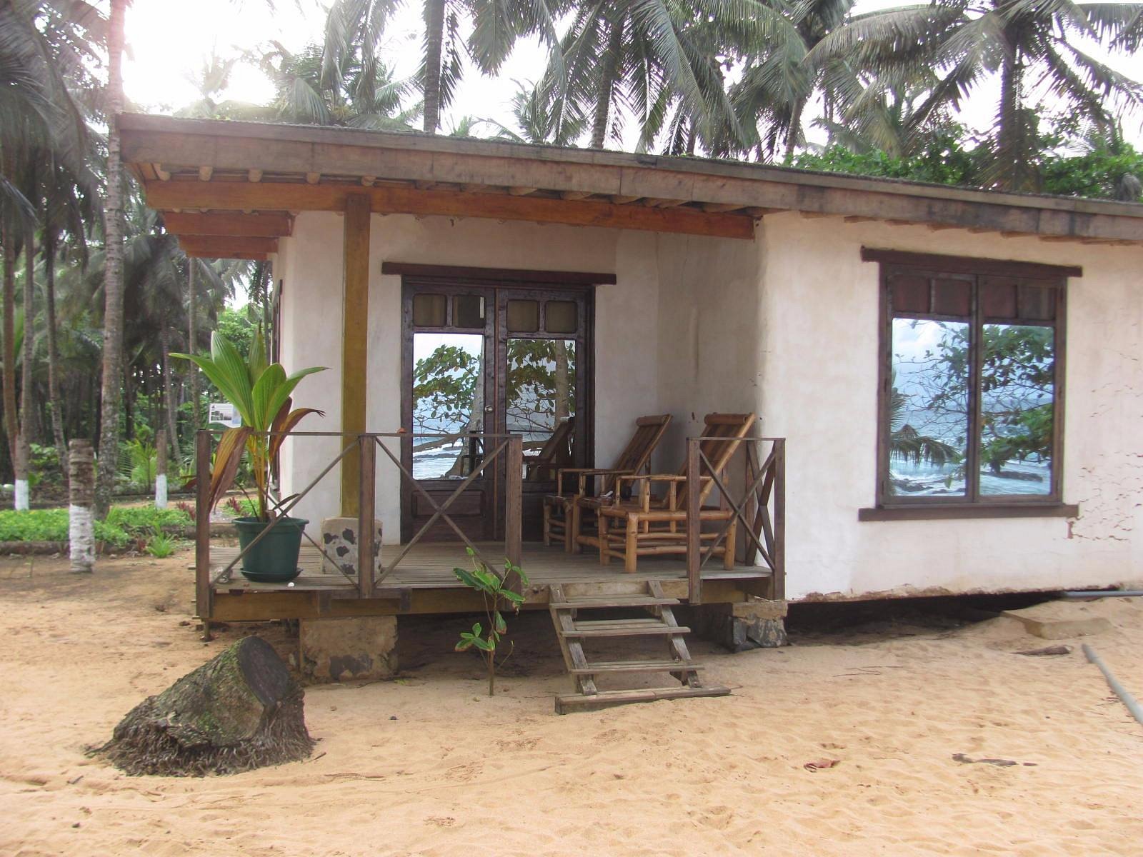 Bungalow veranda with wooden loungers looking out to the Atlantic at Jalé Ecolodge