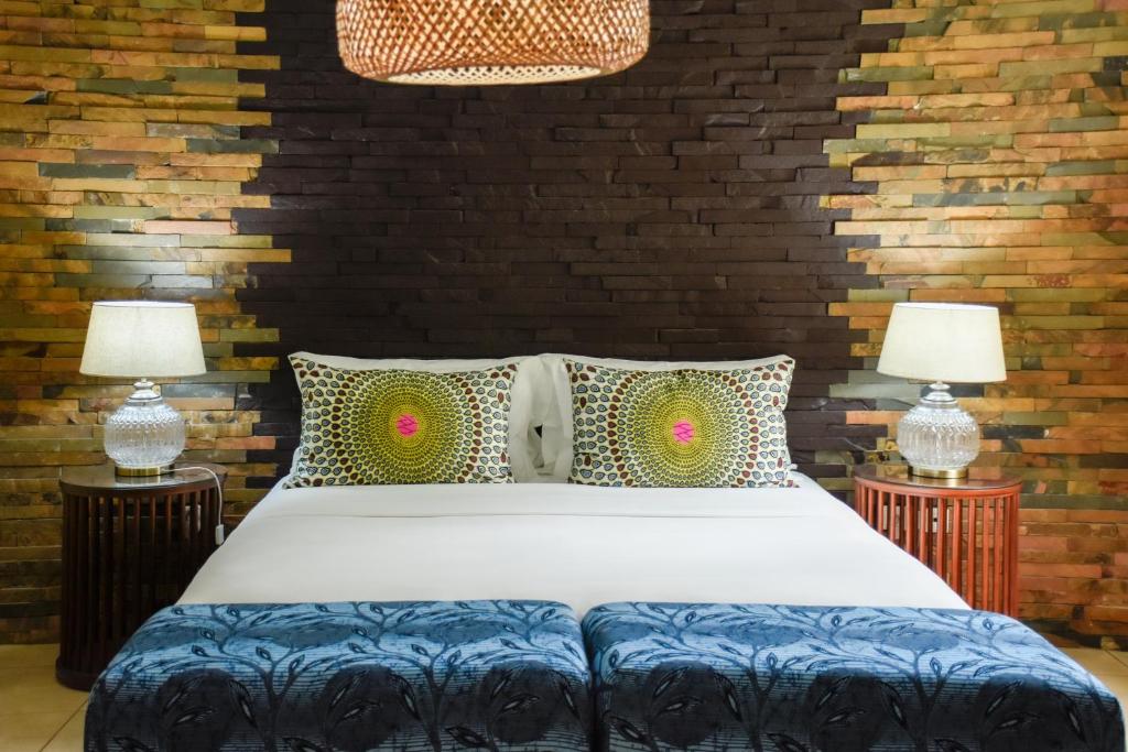 Omali Lodge bedroom with stone feature wall and African-print pillows, São Tomé