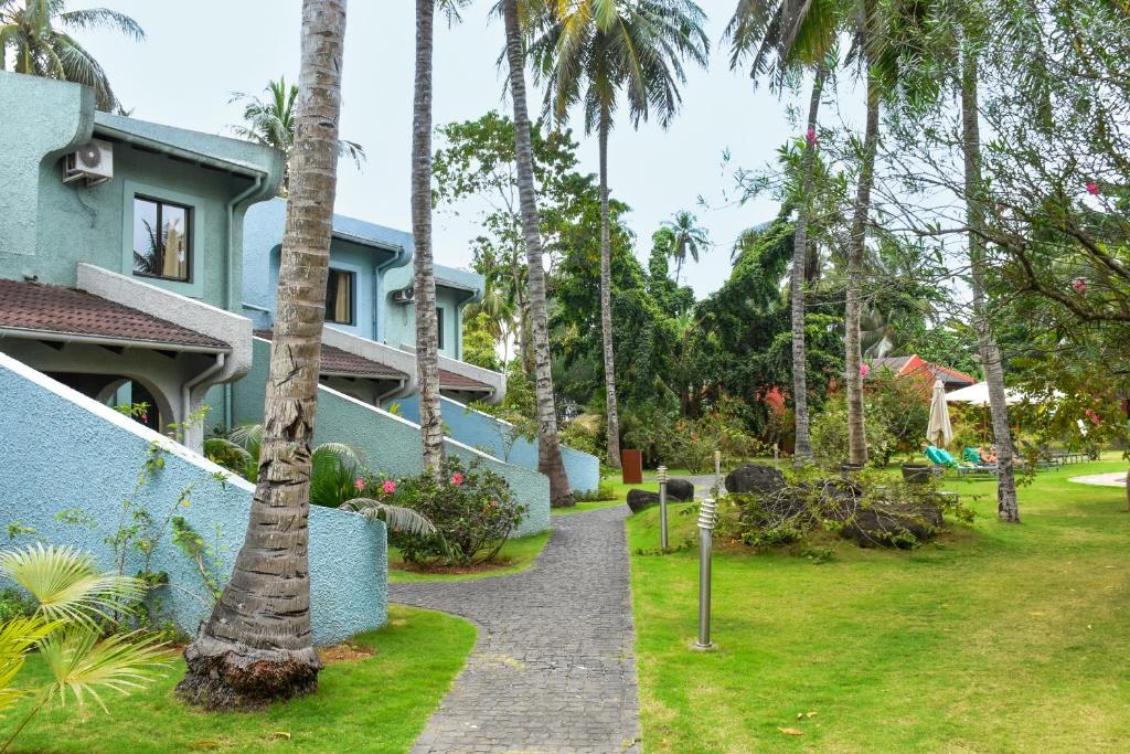 Omali Lodge blue garden buildings and palm-lined pathway, São Tomé